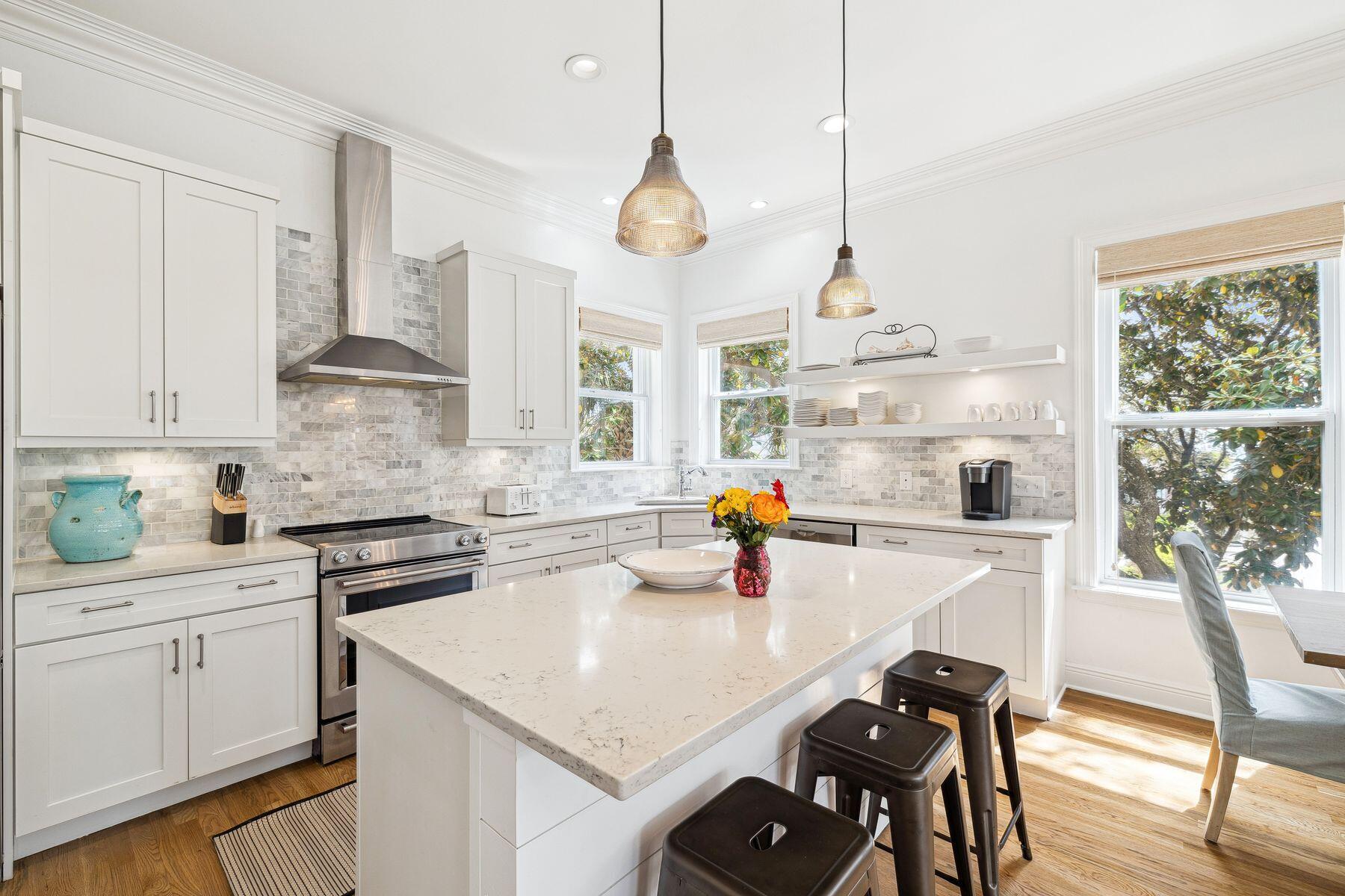 32 Hickory Street Santa Rosa Beach, FL 32459 - Photo 9 of 33 a kitchen with stainless steel appliances a stove a sink a dining table and chairs with white cabinets