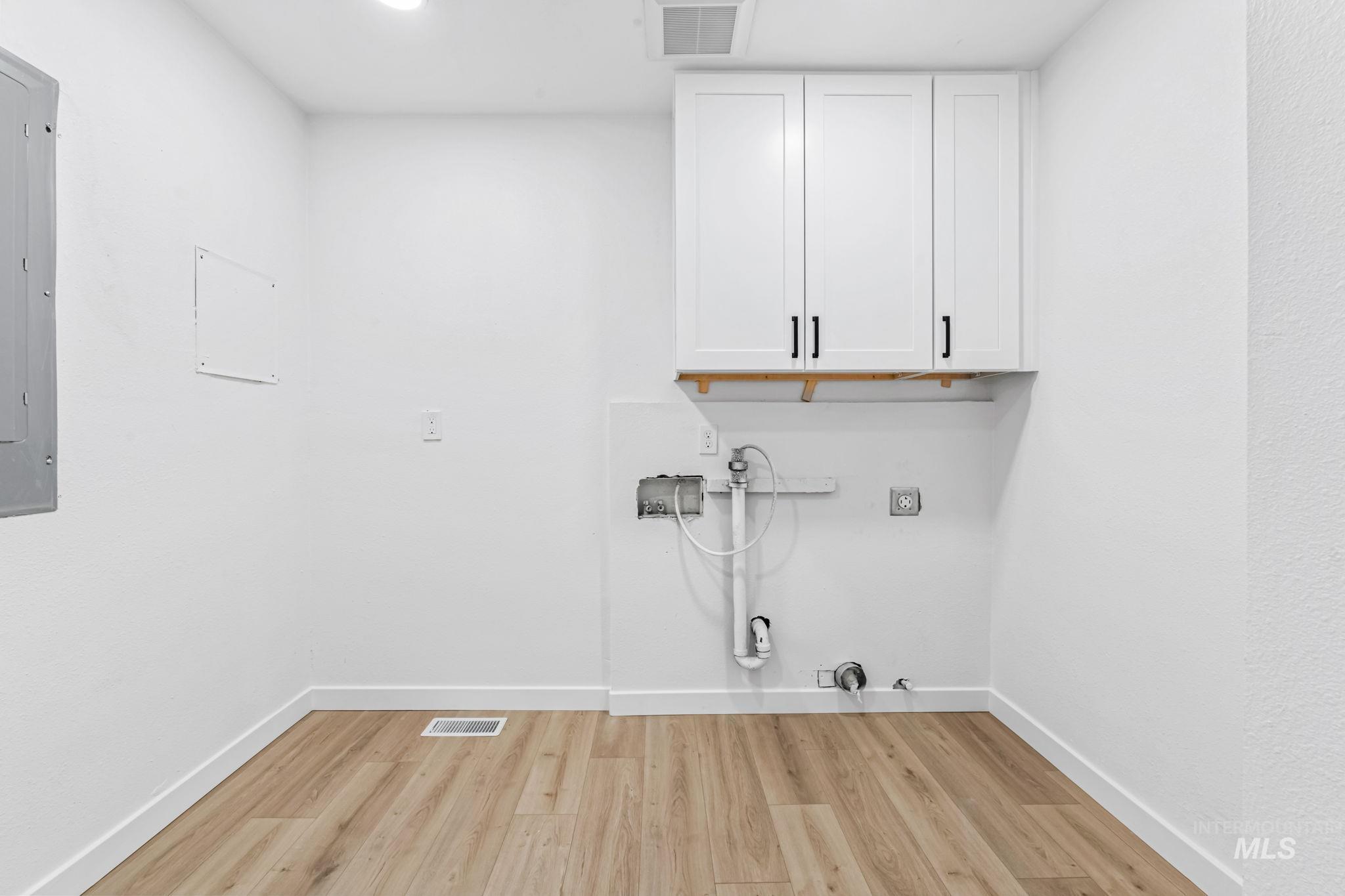 1117 Olds Ferry Road Weiser, ID 83672 - Photo 27 of 35 Laundry room with cabinet space, hookup for a gas dryer, light wood finished floors, hookup for a washing machine, and electric dryer hookup