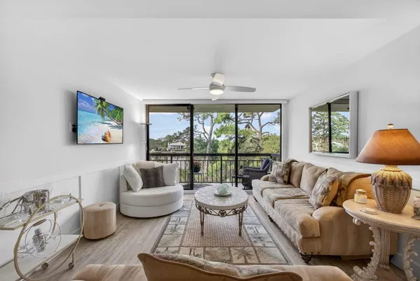 a living room with furniture a rug and a ceiling fan