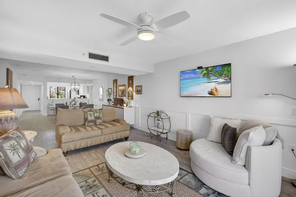 a living room with couches a dining table and chairs with wooden floor