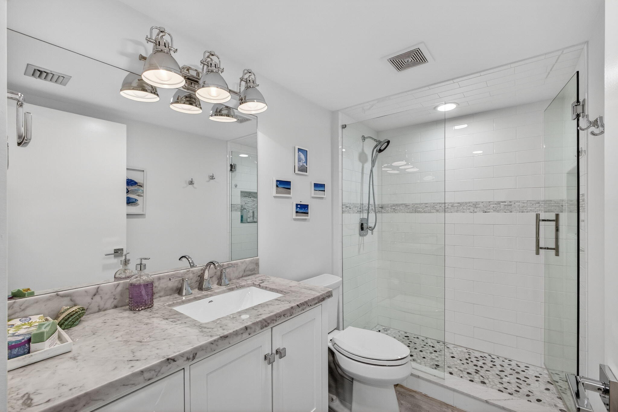1901 Marina Isle Way, Unit 304 Jupiter, FL 33477 - Photo 28 of 64 a bathroom with a granite countertop sink a toilet and shower