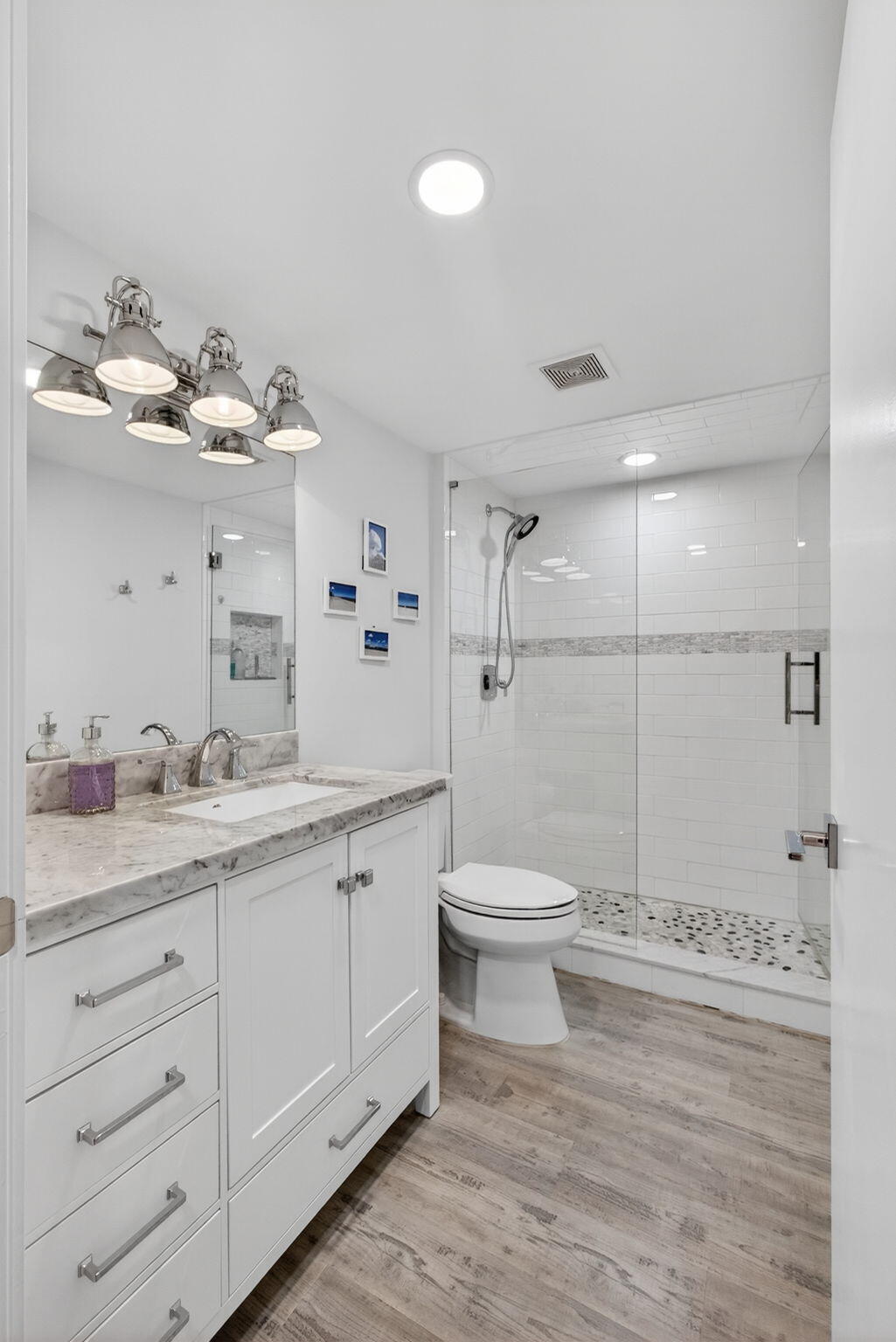 1901 Marina Isle Way, Unit 304 Jupiter, FL 33477 - Photo 29 of 64 a bathroom with a toilet a sink and mirror