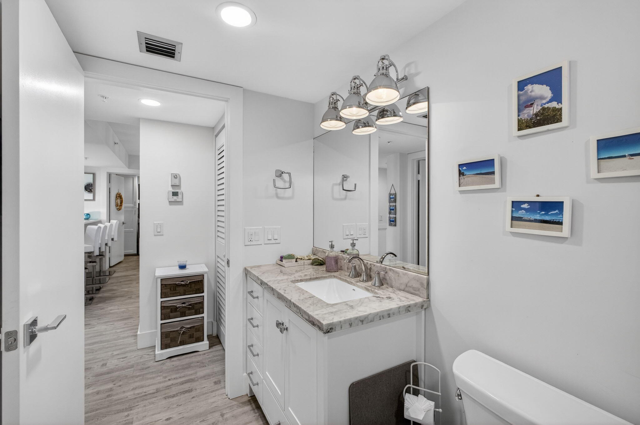 1901 Marina Isle Way, Unit 304 Jupiter, FL 33477 - Photo 30 of 64 a spacious bathroom with a double vanity sink a large mirror and a toilet