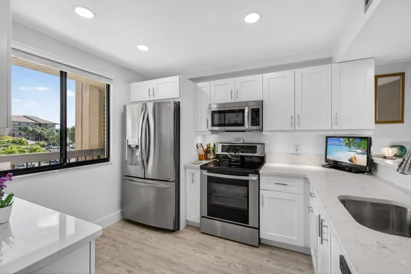 a kitchen with white cabinets and stainless steel appliances