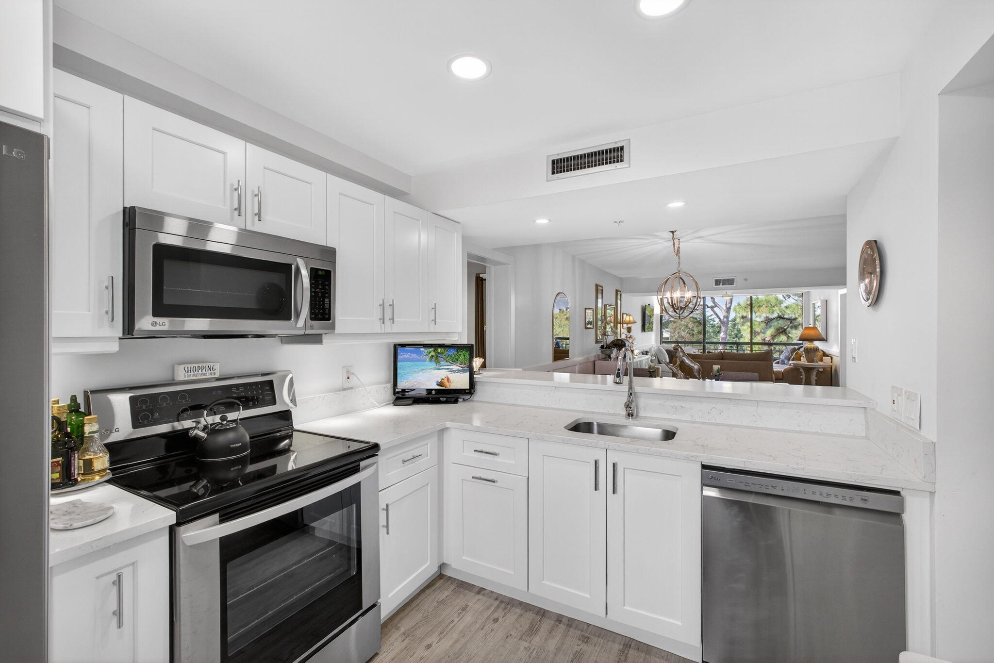 1901 Marina Isle Way, Unit 304 Jupiter, FL 33477 - Photo 7 of 64 a kitchen with white cabinets and stainless steel appliances