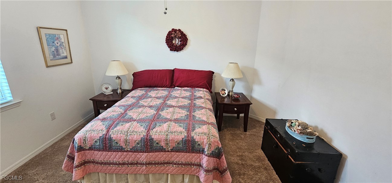 10788 Crossback Lane Lehigh Acres, FL 33936 - Photo 27 of 32 a bedroom with a bed and a chandelier