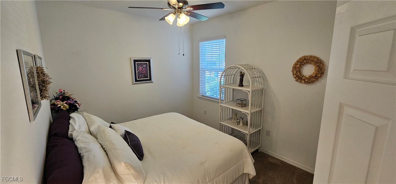 10788 Crossback Lane Lehigh Acres, FL 33936 - Photo 29 of 32 a bedroom with a bed and a chandelier