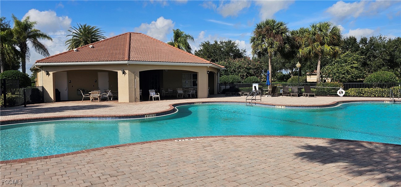 10788 Crossback Lane Lehigh Acres, FL 33936 - Photo 31 of 32 a view of a white house with a big yard and potted plants