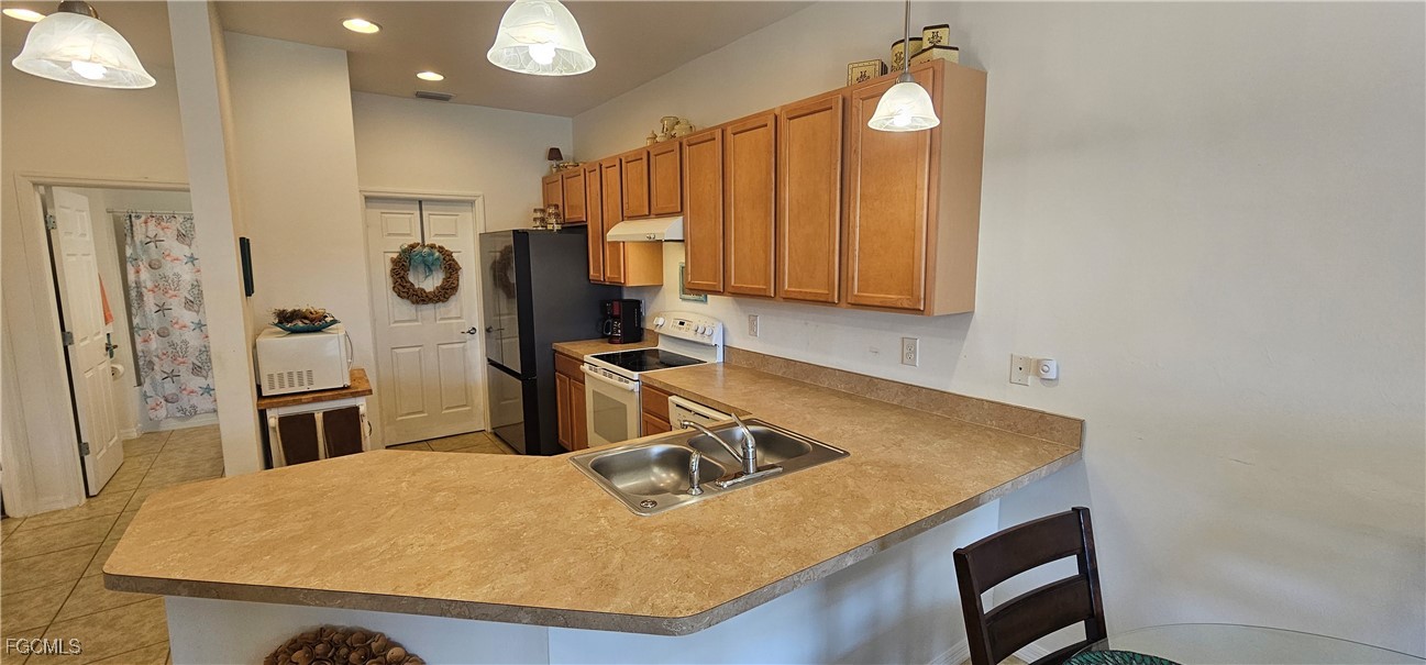 10788 Crossback Lane Lehigh Acres, FL 33936 - Photo 9 of 32 a kitchen with refrigerator and window