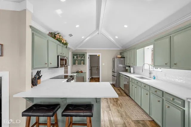 a kitchen with kitchen island a sink table and chairs