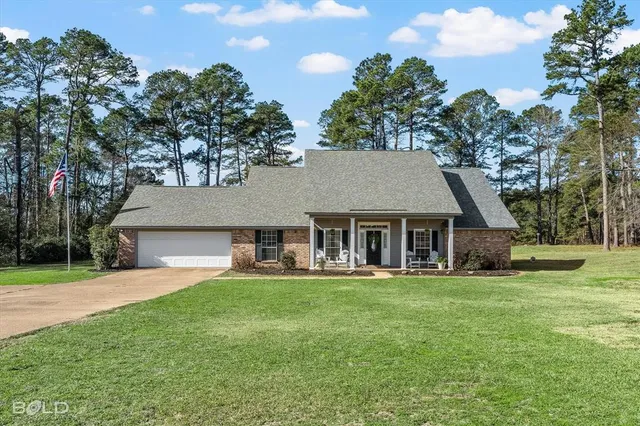 front view of a house with a yard and trees