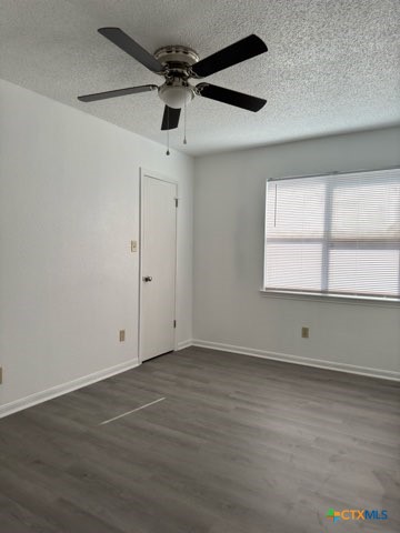 1815 Cedarhill Drive, Unit C Killeen, TX 76543 - Photo 26 of 27 an empty room with wooden floor and windows