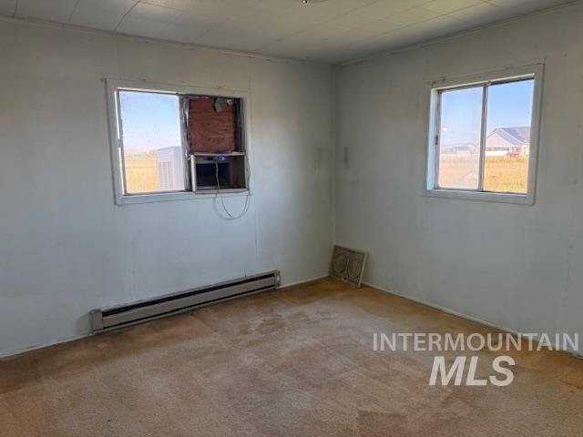 2900 West Sales Yard Road Emmett, ID 83617 - Photo 10 of 18 Empty room featuring baseboard heating, light colored carpet, and cooling unit