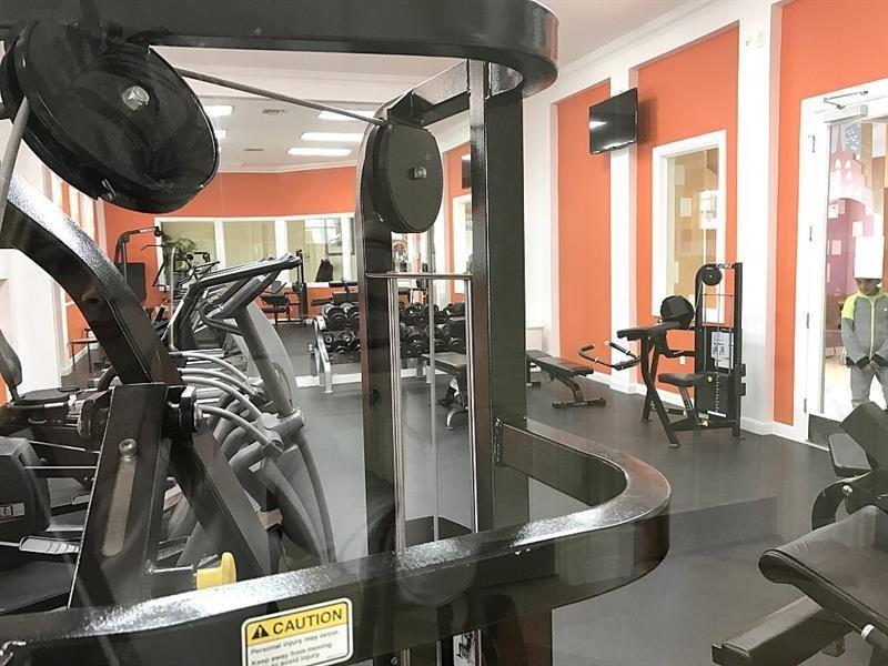 5840 West Sample Road, Unit 103 Coral Springs, FL 33067 - Photo 4 of 9 a view of gym equipment and a living room