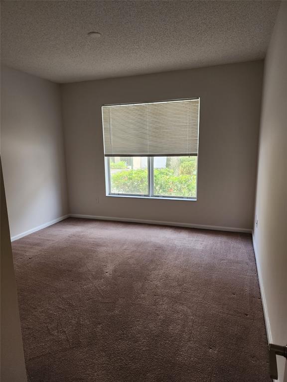 5840 West Sample Road, Unit 103 Coral Springs, FL 33067 - Photo 7 of 9 an empty room with a window