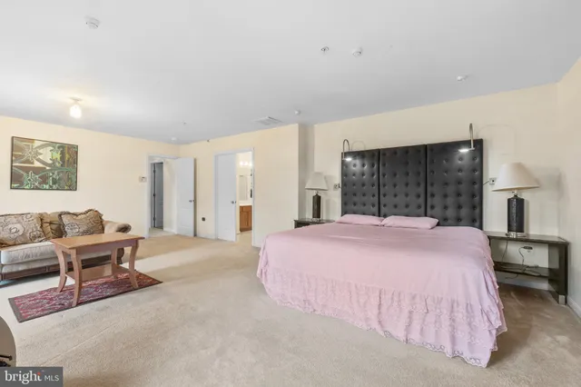 a spacious bedroom with a bed a table and chair