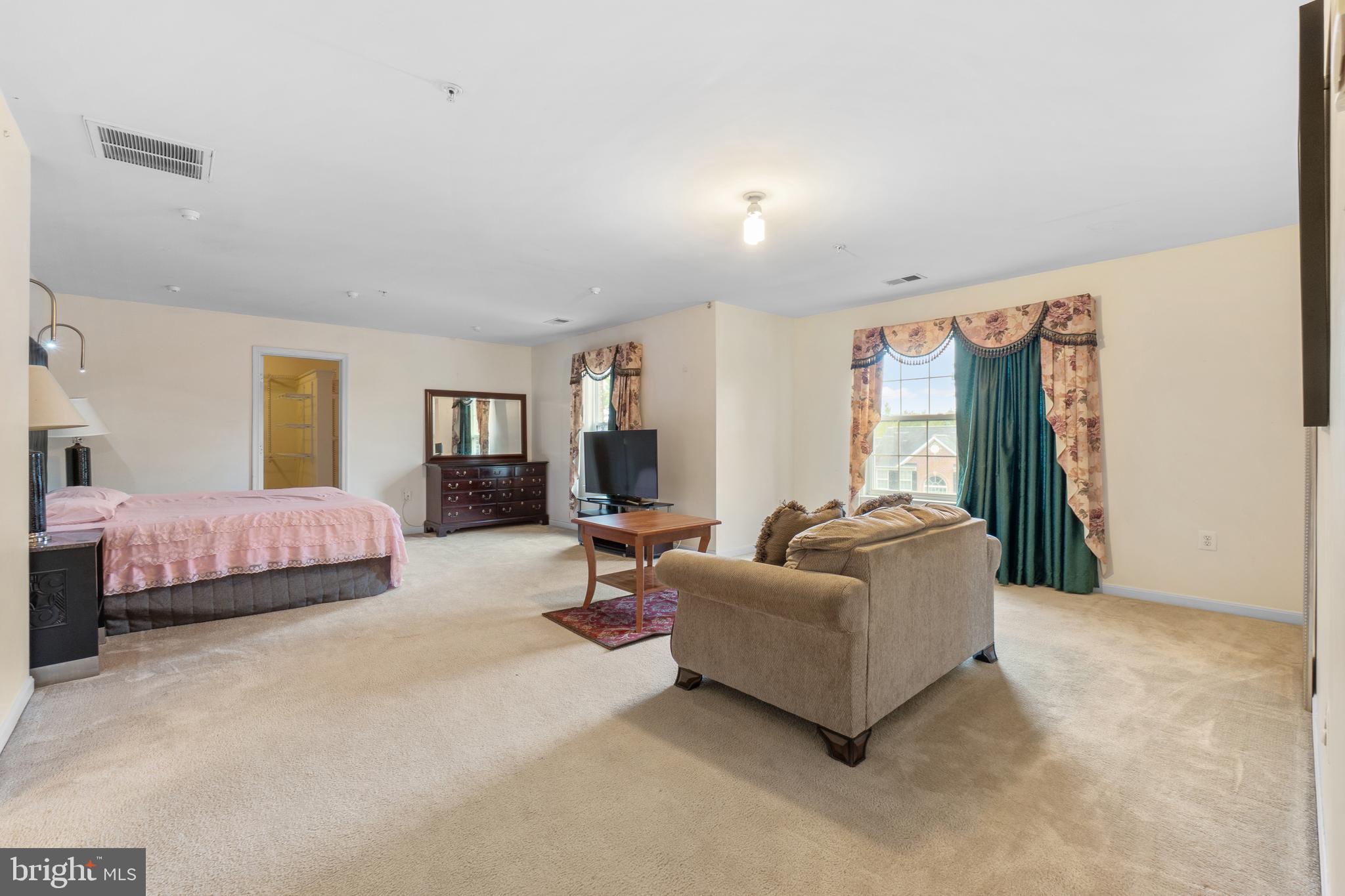 10107 Mike Road Fort Washington, MD 20744 - Photo 15 of 35 a spacious bedroom with a bed and a couch