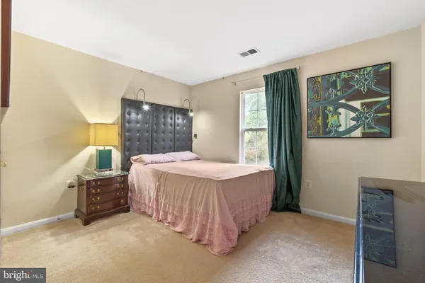 a bedroom with a bed dresser and a window