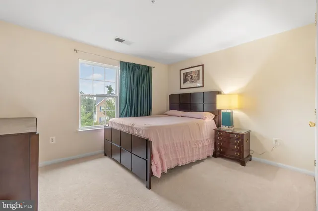 a bedroom with a bed lamp and a window
