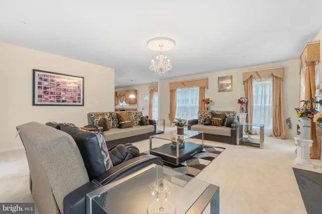 a living room with furniture chandelier and a large window