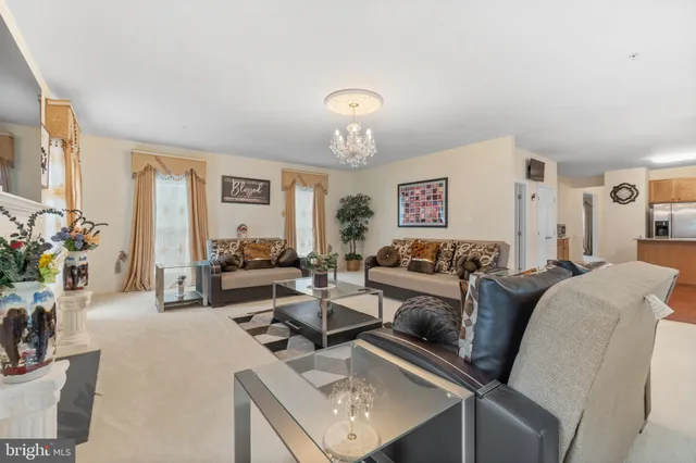 a living room with furniture a chandelier and a flat screen tv