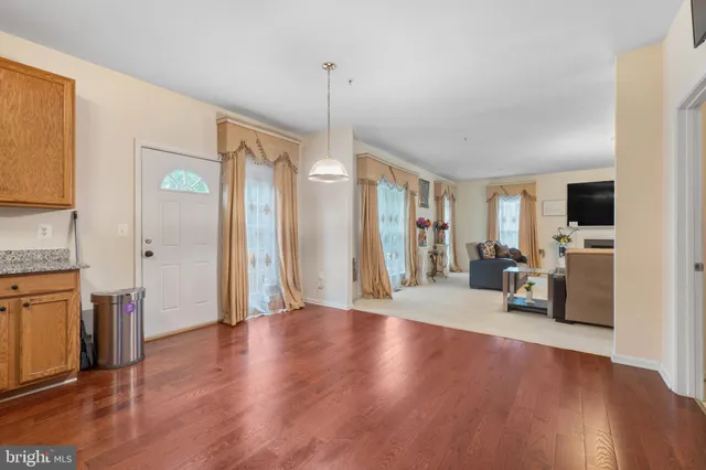 a view of a livingroom with furniture a flat screen tv and refrigerator