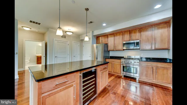 a large kitchen with stainless steel appliances granite countertop a lot of counter space and a sink