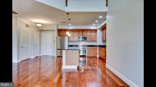 a kitchen with stainless steel appliances granite countertop a refrigerator a sink and a stove