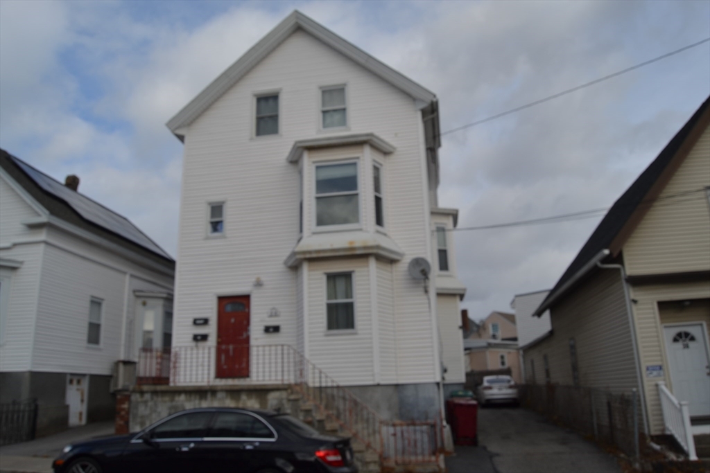 32 Wamesit Street, Unit 3 Lowell, MA 01852 - Photo 14 of 14 a front view of a house with a car parked