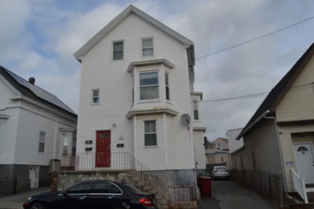 a front view of a house with a car parked