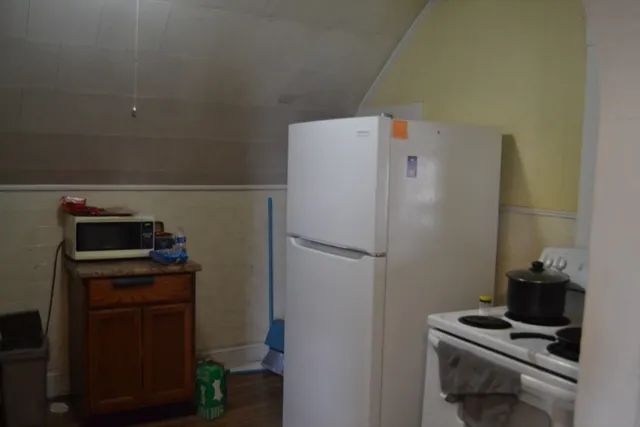 a white refrigerator freezer and a stove sitting inside of a kitchen
