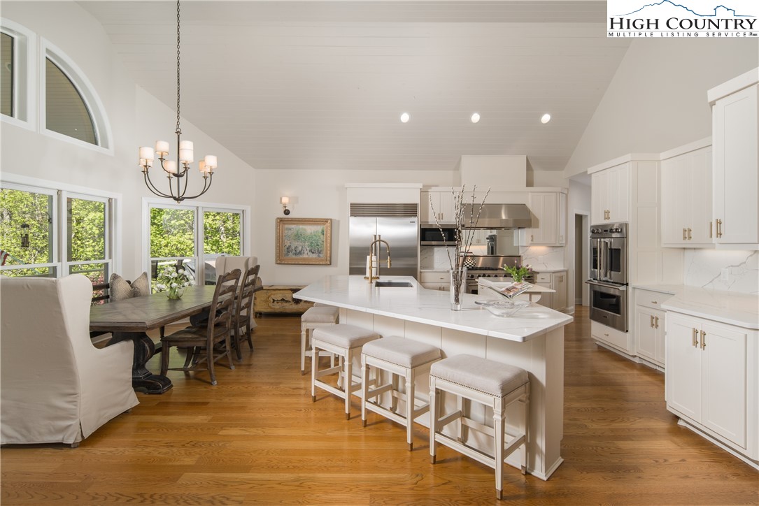 1005 Evergreen Drive Boone, NC 28607 - Photo 7 of 44 a large dining hall with stainless steel appliances granite countertop a stove top oven a dining table and chairs with wooden floor