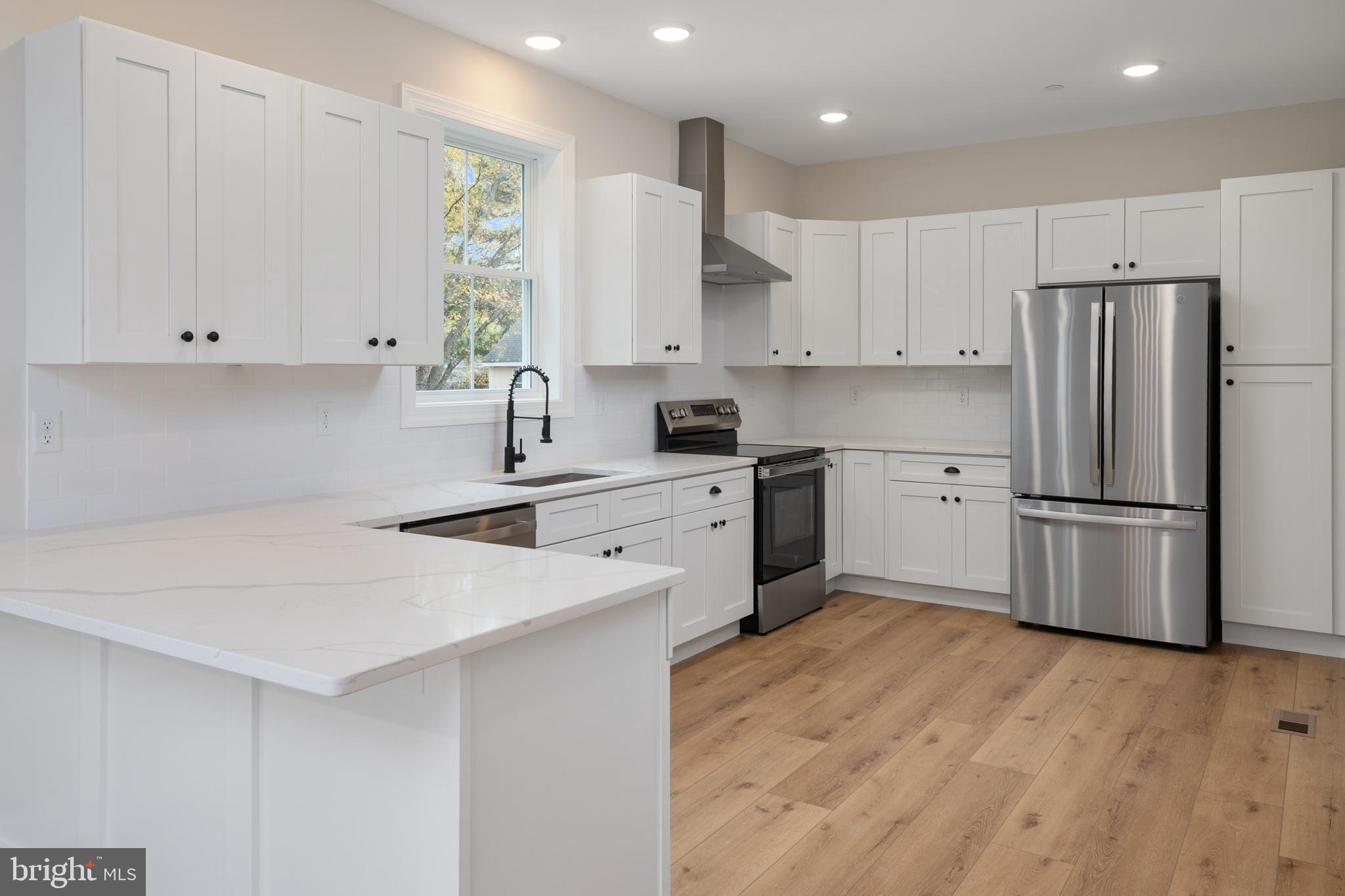 208 Long Point Road Stevensville, MD 21666 - Photo 12 of 52 a kitchen with a sink a refrigerator and white cabinets