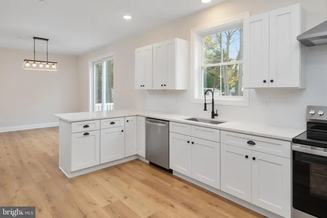 a kitchen with granite countertop a sink cabinets and wooden floor