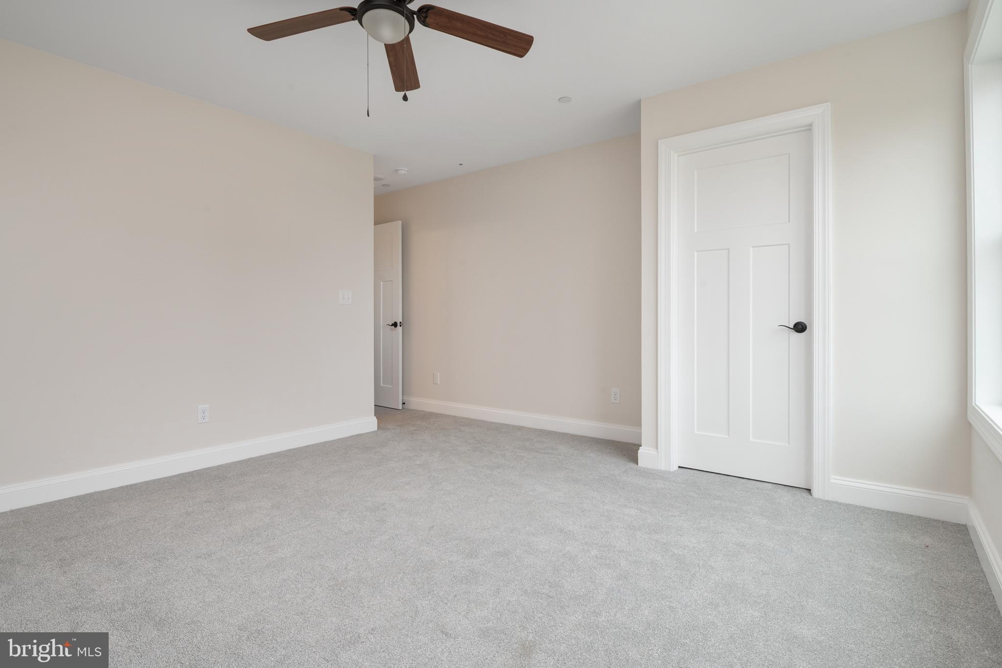 208 Long Point Road Stevensville, MD 21666 - Photo 23 of 52 an empty room with a ceiling fan and carpet