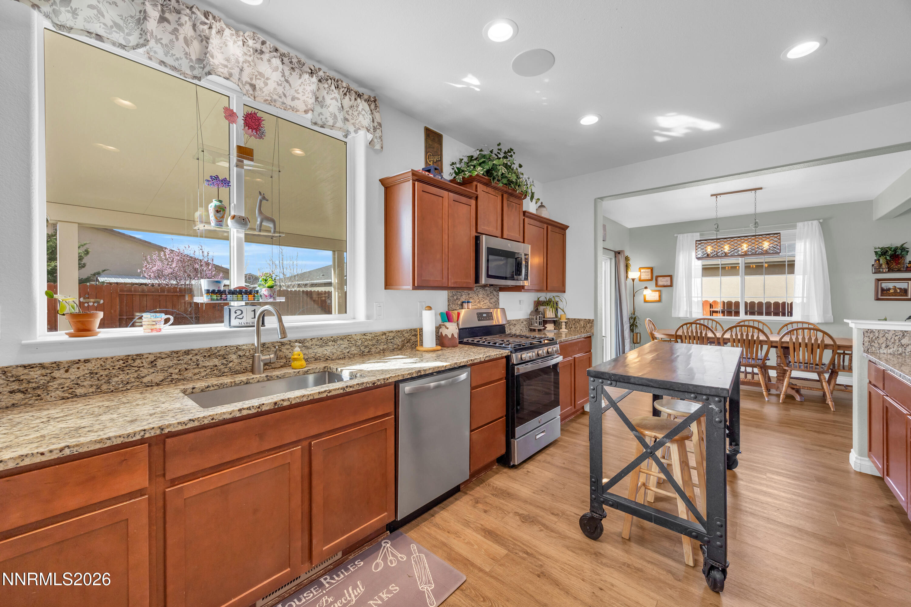 18648 Granite Peak Court Reno, NV 89508 - Photo 13 of 53 a kitchen with stainless steel appliances granite countertop sink stove dining table and chairs