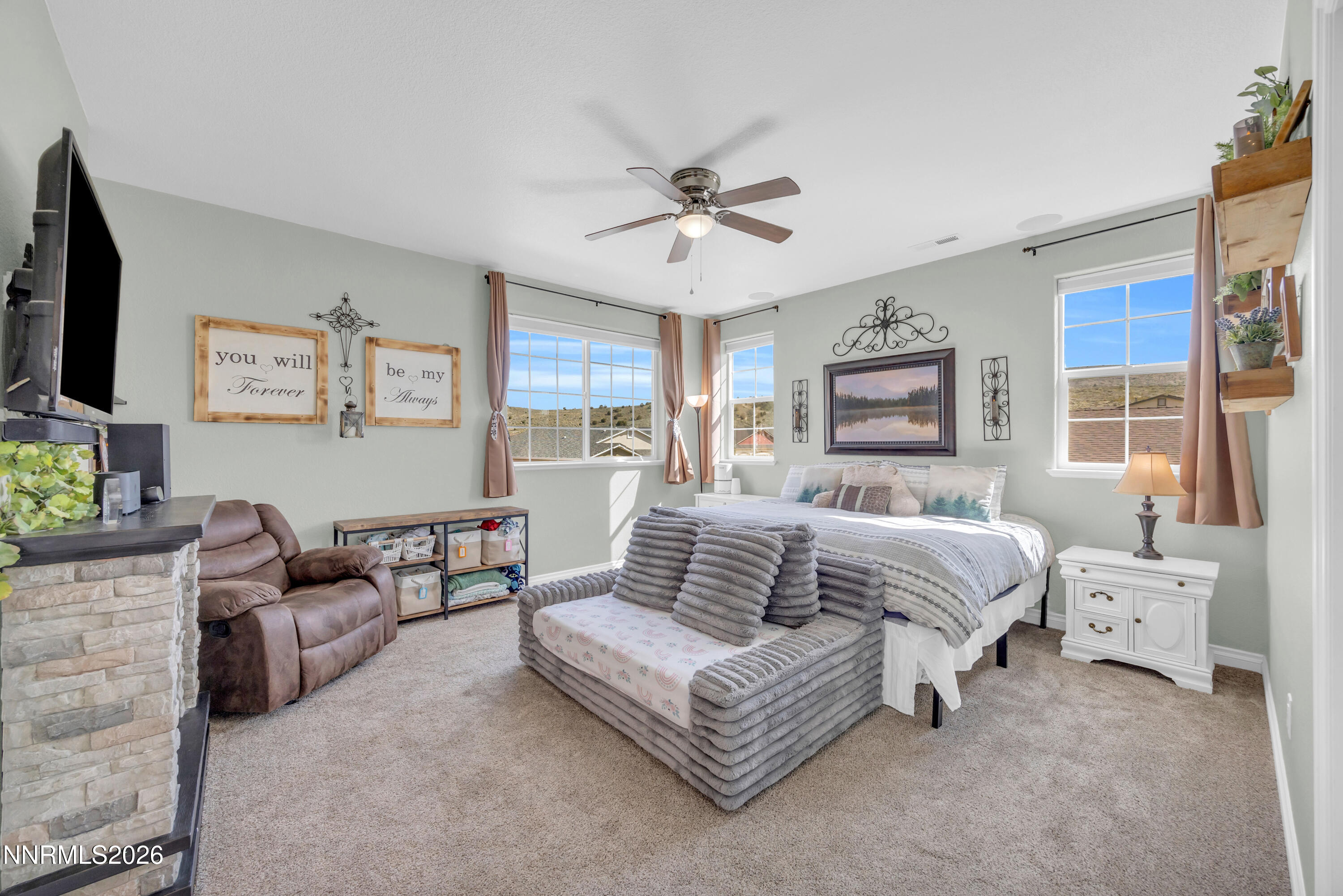 18648 Granite Peak Court Reno, NV 89508 - Photo 23 of 53 a spacious bedroom with a bed couches and a flat tv screen