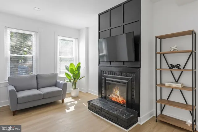 a living room with furniture a flat screen tv and a fireplace