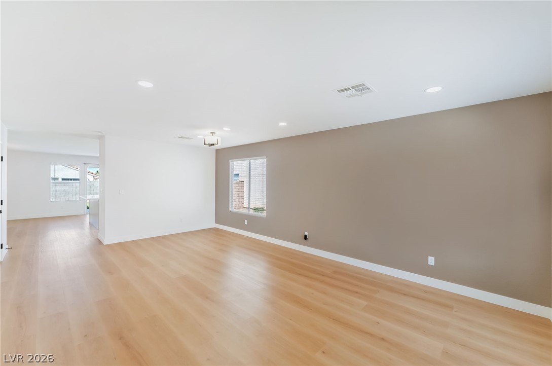 668 Rising Brook Drive Henderson, NV 89011 - Photo 3 of 22 Blonde hardwood floors flow through this sun-filled living space, offering an inviting blank canvas.