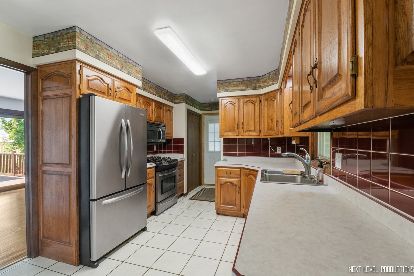 14900 Sears Road Plano, IL 60545 - Photo 10 of 31 a kitchen with stainless steel appliances granite countertop a refrigerator a stove and a sink with wooden cabinets