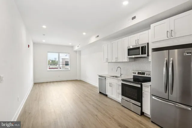 a kitchen with granite countertop a refrigerator stove and microwave