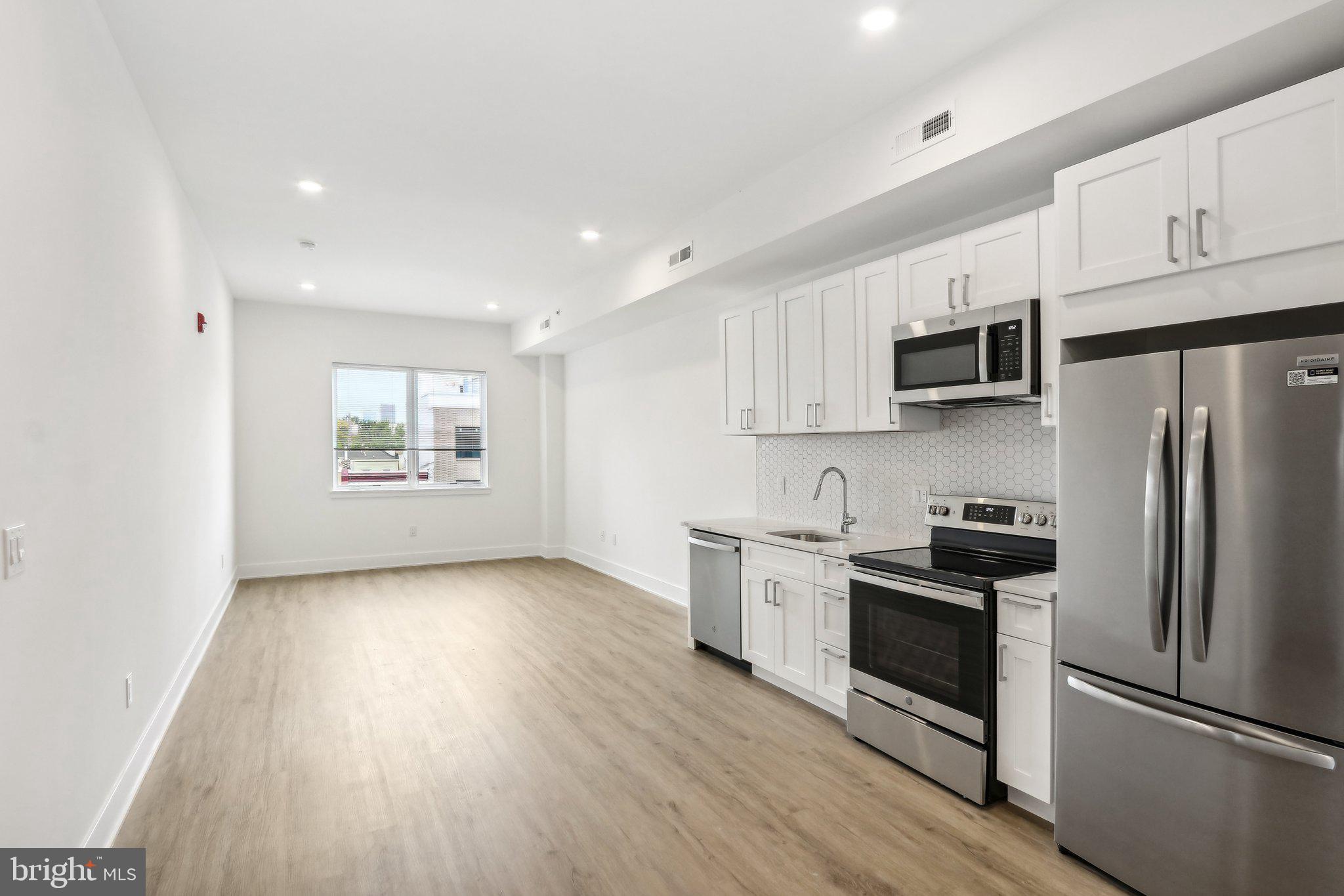 1622 Point Breeze Avenue, Unit 410 Philadelphia, PA 19145 - Photo 1 of 20 a kitchen with granite countertop a refrigerator stove and microwave