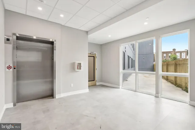 an empty room with glass door and shower
