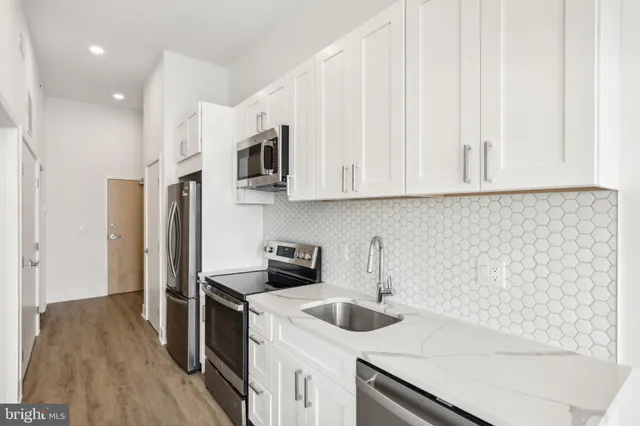 a kitchen with stainless steel appliances granite countertop a refrigerator and a stove top oven