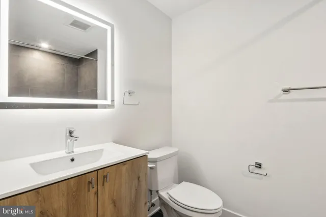 a bathroom with a sink mirror vanity and toilet