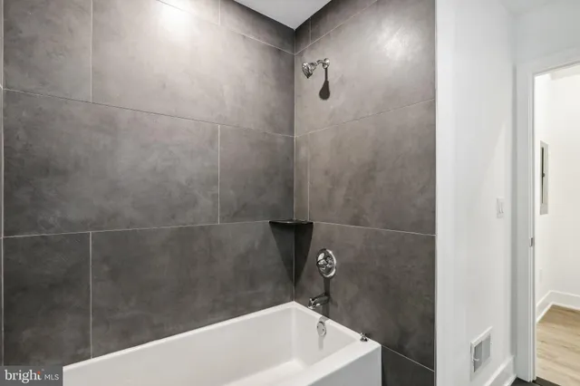 a bathroom with a white bath tub and a shower