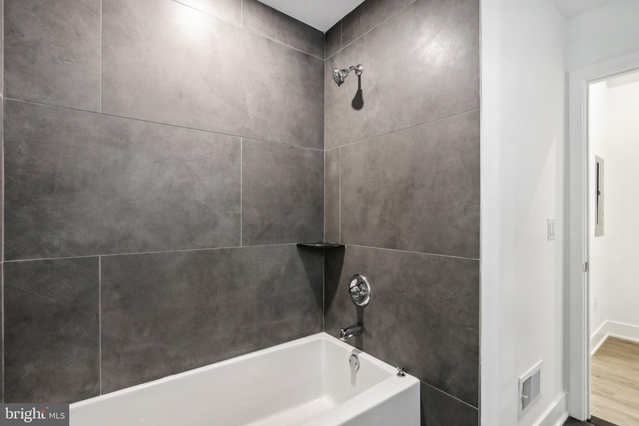 1622 Point Breeze Avenue, Unit 410 Philadelphia, PA 19145 - Photo 9 of 20 a bathroom with a white bath tub and a shower