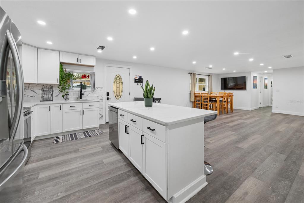 1353 Chatauqua Way Keystone Heights, FL 32656 - Photo 21 of 60 a kitchen with stainless steel appliances kitchen island granite countertop a sink a stove a refrigerator and a oven with wooden floor