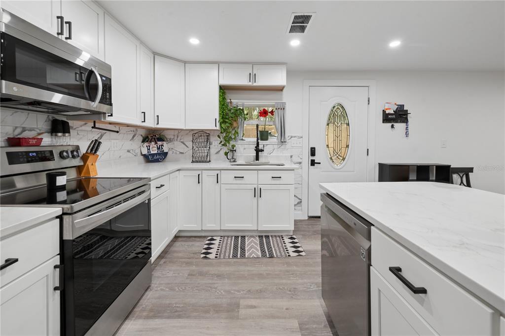 1353 Chatauqua Way Keystone Heights, FL 32656 - Photo 23 of 60 a kitchen with stainless steel appliances kitchen island granite countertop a sink and cabinets