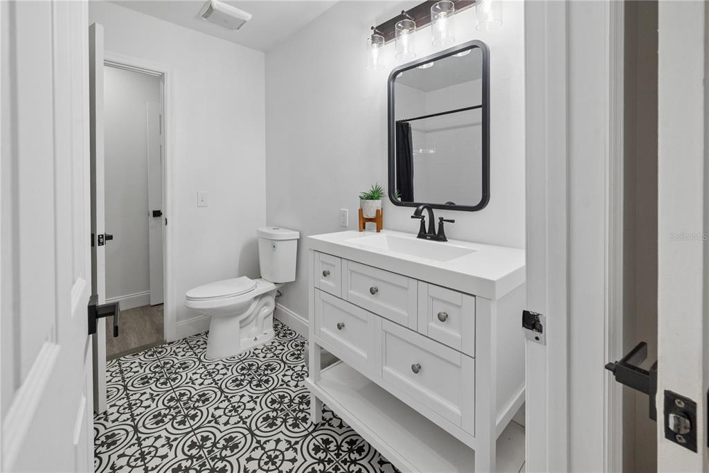1353 Chatauqua Way Keystone Heights, FL 32656 - Photo 38 of 60 a bathroom with a toilet a sink a mirror and a shower